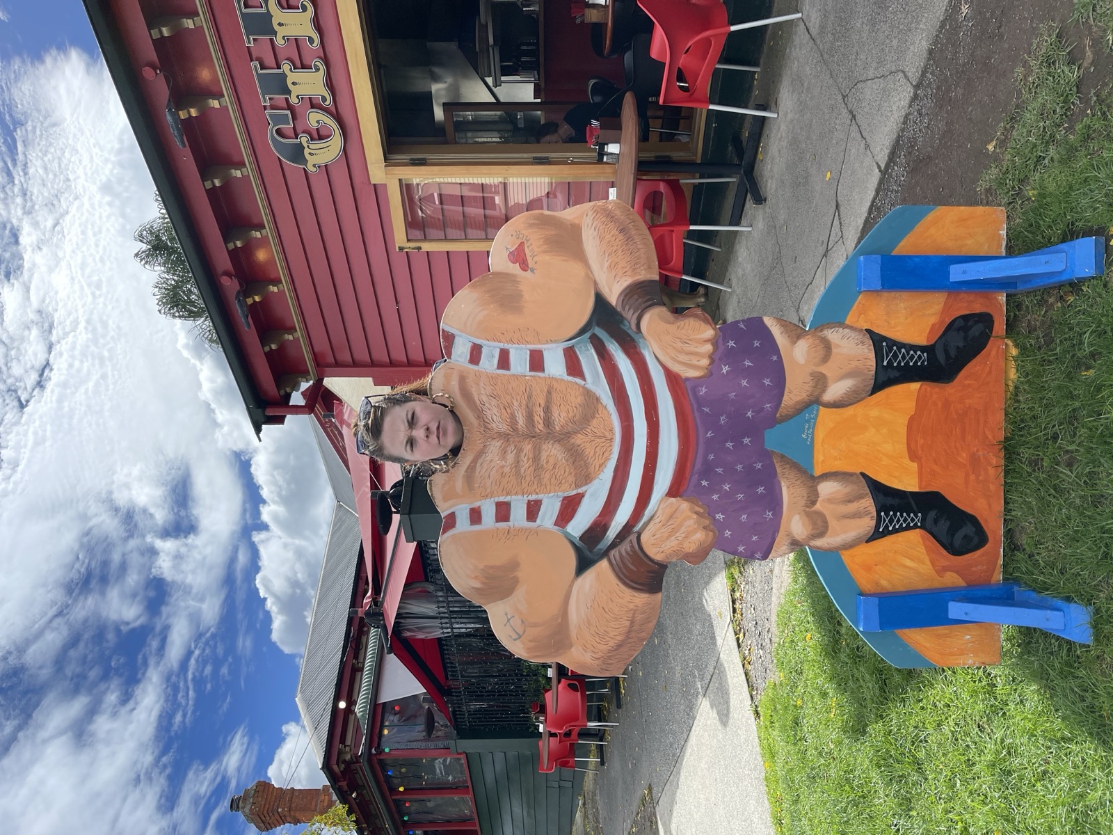 Lisa posing behind a muscular statue